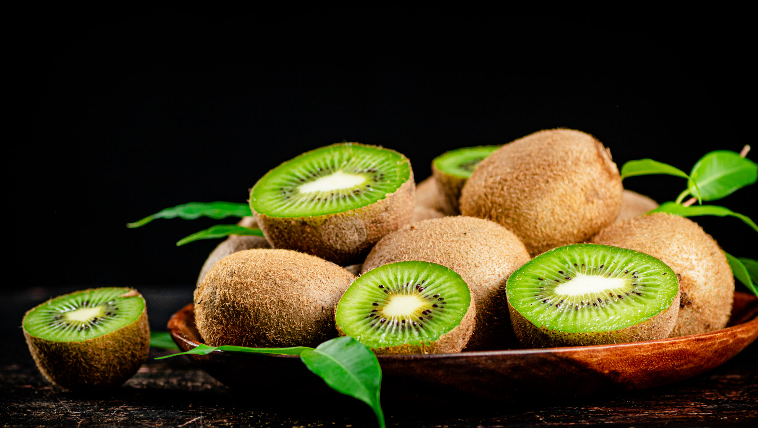fresh kiwi with leaves on a wooden plate 2024 09 12 19 43 26 utc scaled
